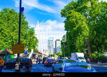 Blick auf die Golden Jubilee Bridge von der Northumberland Avenue - Fußgängerbrücken mit Kabelgestellen, die sich die Fundamente`s der Eisenbahnbrücke teilen. Stockfoto